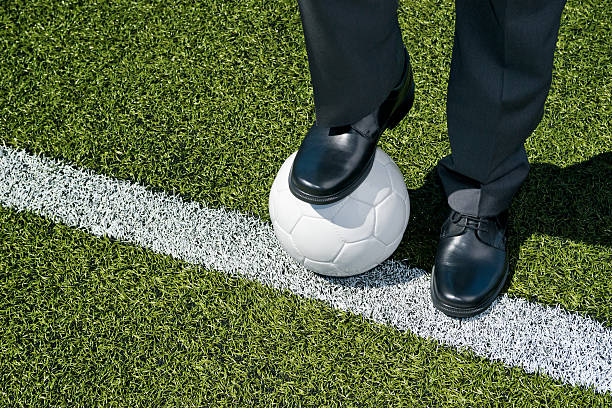 Businessman playing with a soccer ball stock photo