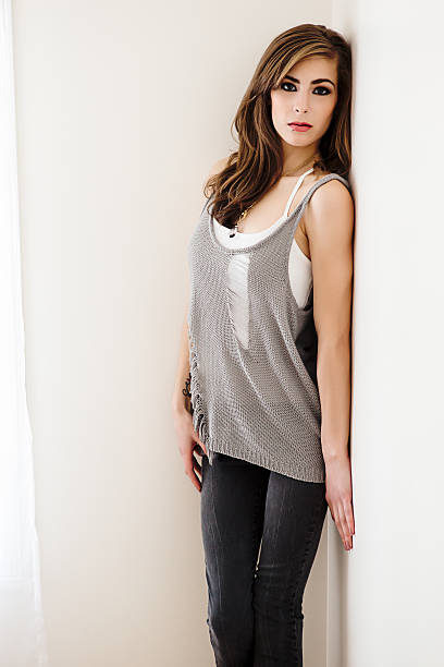 Beautiful young woman standing against wall