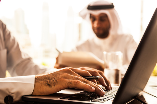 Dos hombres de negocios de Emiratos llenado documentos en un café photo