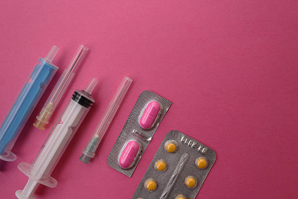 istock Syringe, needle and pills on pink background - medicine concept 498941056