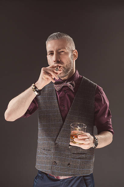 elegante homem beber whisky escocês e de fumar charuto - men elegance cocktail cool imagens e fotografias de stock