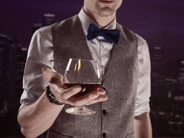 elegante homem segurando copo balão para brandy - men elegance cocktail cool imagens e fotografias de stock