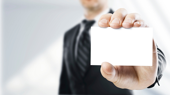 man handing a blank business card over white background