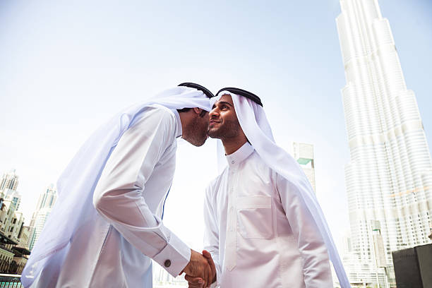 Emirates Business men downtown Dubai Two emirates business people wearing traditional dish dasha clothing doing business in financial district in Dubai, UAE. hello stock pictures, royalty-free photos & images