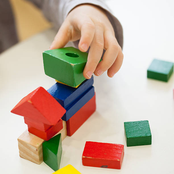istock Child play with colored wooden brick shapes 498948872