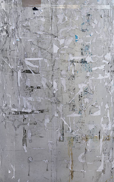 istock Grey wall covered with old paper scraps and glue 498949750