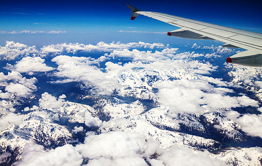 Flight over the Alps, snow-capped Alpine peaks visible glacier. Italy