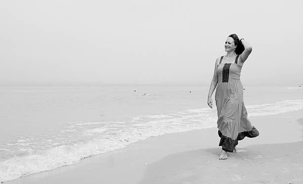 istock Beautiful woman standing on the beach 498954562