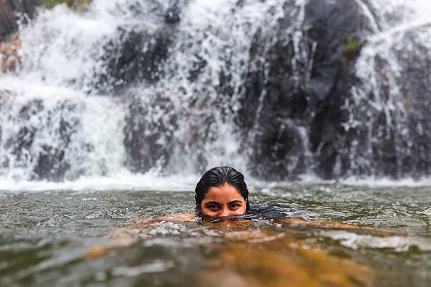 istock Girl swimming at waterfall 498955662