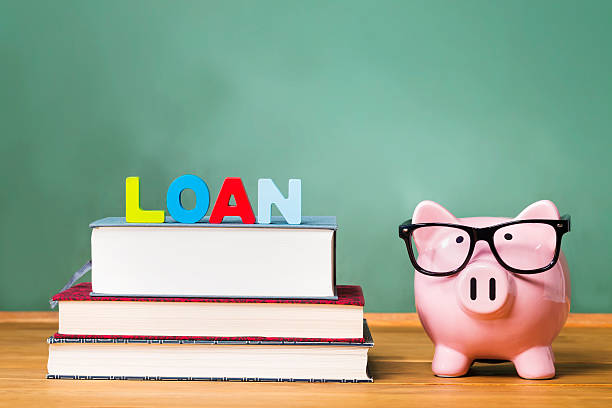 istock Student loan theme with textbooks and piggy bank 498973352