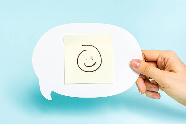Happy emoticon on speech bubble on blue background. Well done, card feedback, employee recognition concept. Happy emoticon on speech bubble on blue background. client engagement stock pictures, royalty-free photos & images