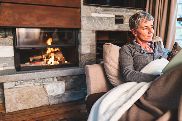 istock woman reading a book on the couch 498974850
