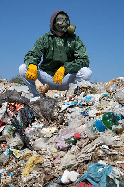 istock Man in a gas mask sitting on the garbage 498974933