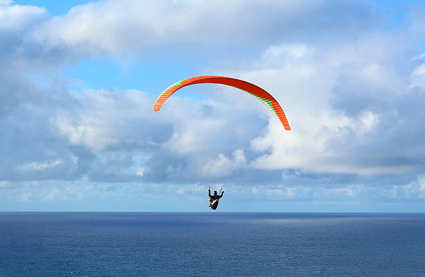 Hang Glider Hang Glider flying over the ocean on a sunny day glider hang glider hanging sky stock pictures, royalty-free photos & images