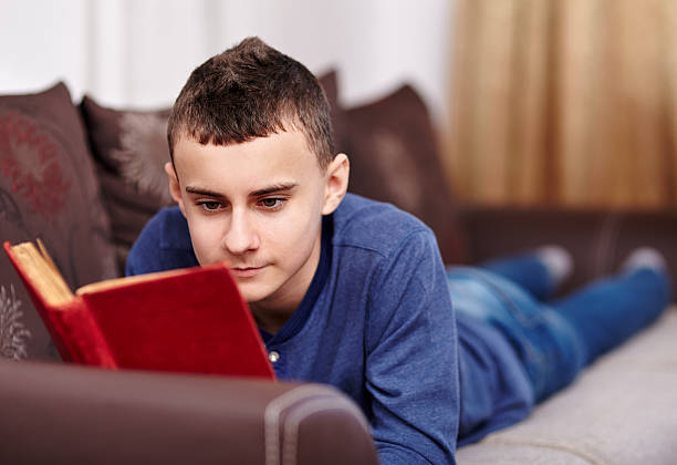 istock Teenager reading a book 498975202