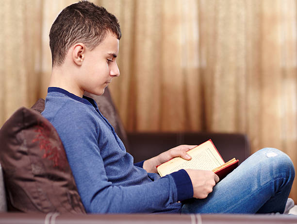 istock Teenager reading a book 498975232
