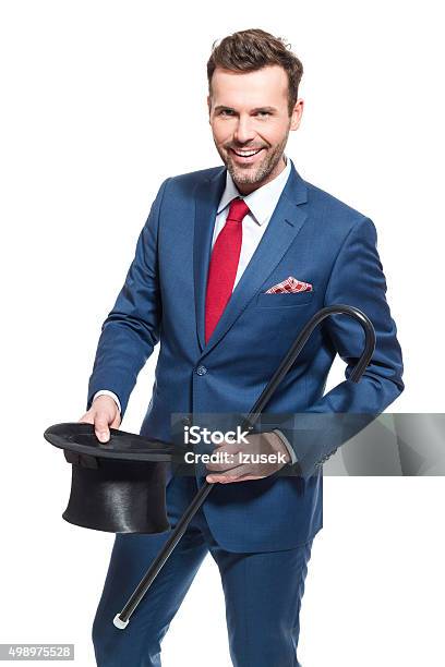 Happy Businessman Wearing Suit Holding Cylinder Hat And Walking Cane Stock Photo - Download Image Now