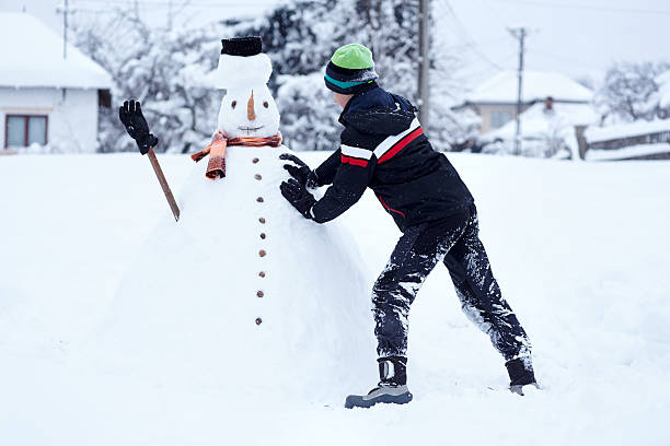 istock Teenager building a snowman 498975904