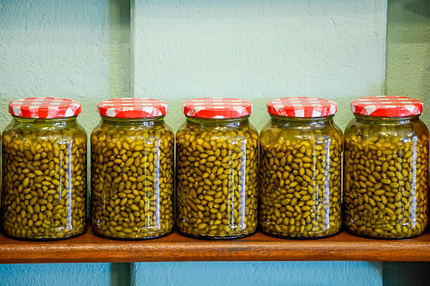 Jars of traditional Brazilian peppers, arranged on a shelf.