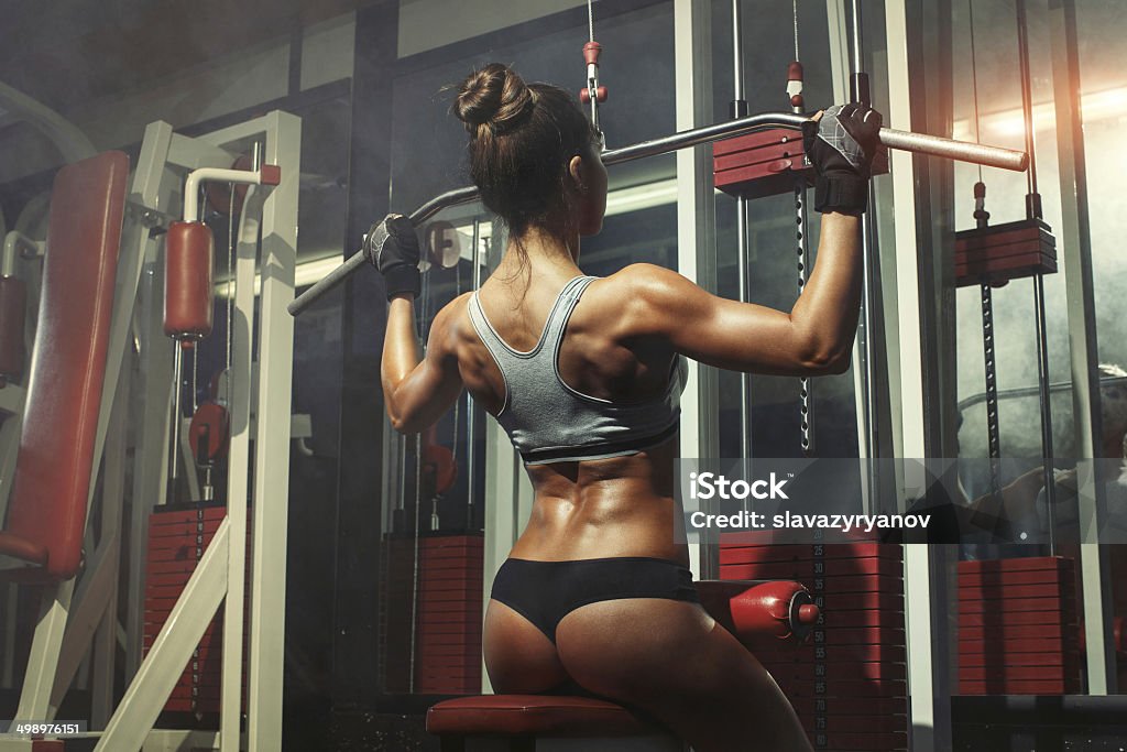 Donna impegnata nel simulatore in palestra - Foto stock royalty-free di Abbigliamento