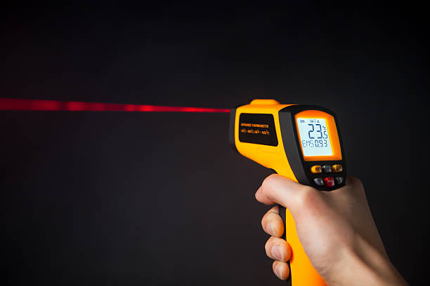 infrarot-laser-thermometer in der hand - distance measurer stock-fotos und bilder