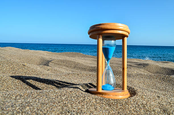 istock Hourglass Clock on the Sand Beach 498977186