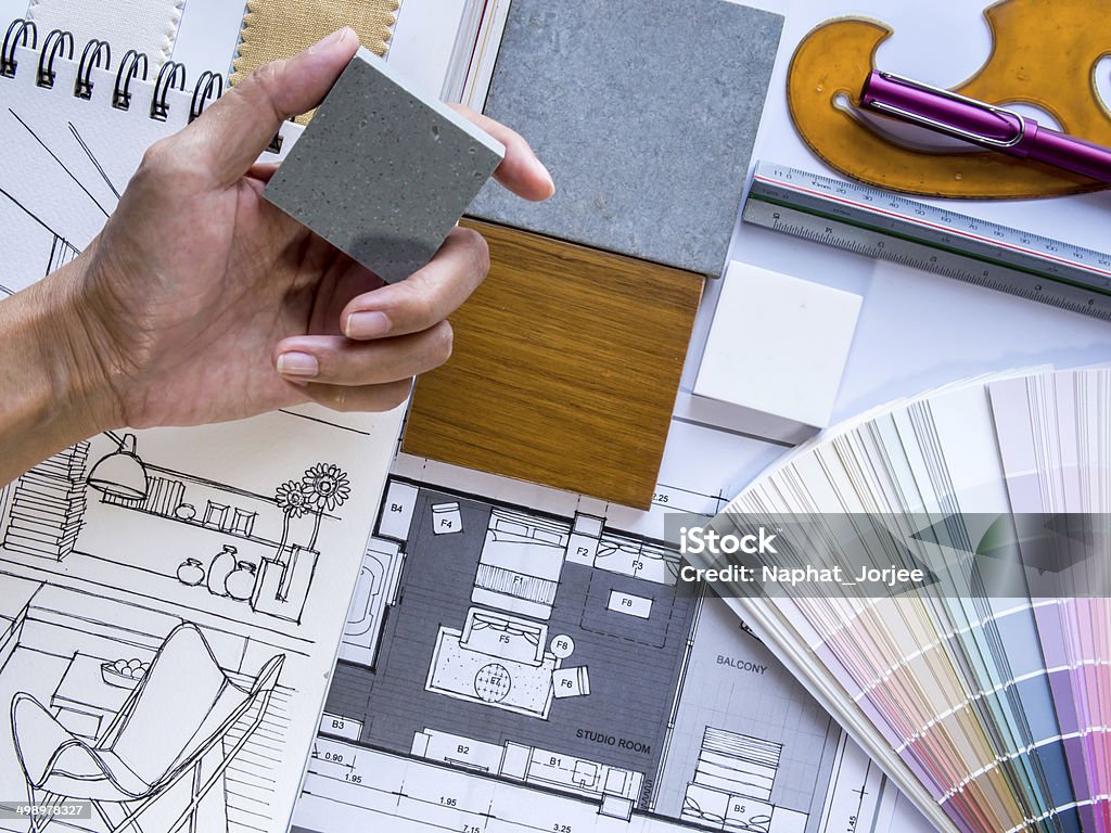 Interior designer's  hand working with illustration sketch and color samples Interior designer's  hand working with illustration sketch,  material and color samples Architecture Stock Photo
