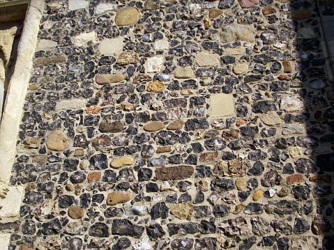 Pieces of ornamental flint cut, knapped and set into the stone of a church wall.