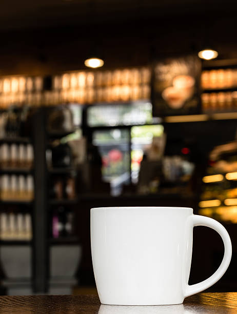 Blanco taza de café en la mesa de madera en la cafetería con Copyspace - foto de stock