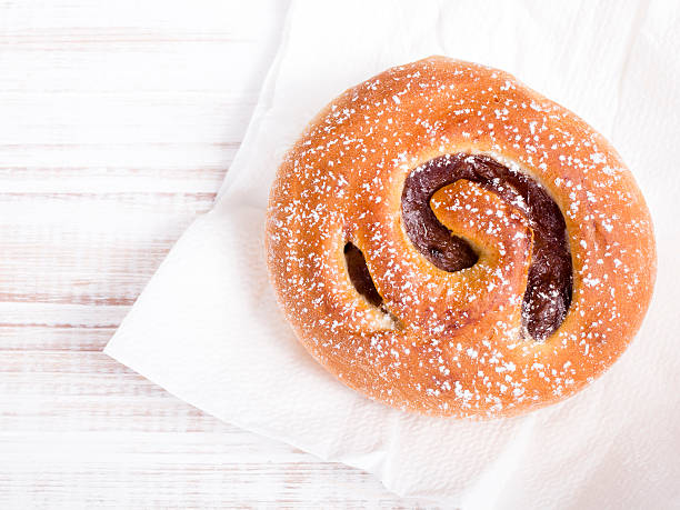 Sweet bun on white wooden background