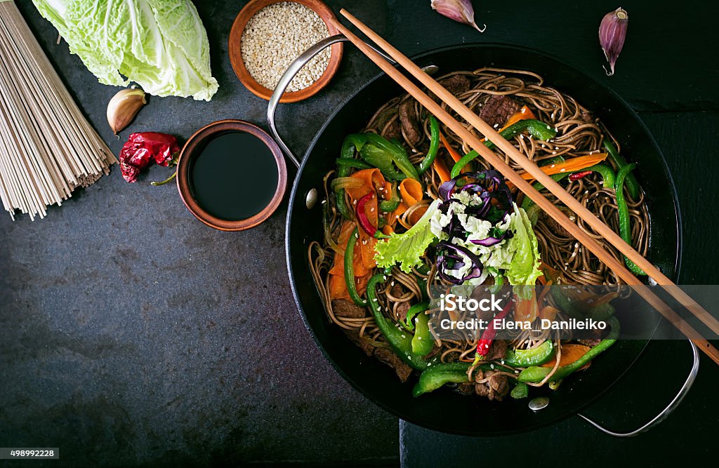 Soba noodles com carne bovina, cebolas, cenouras e pimenta doce - Foto de stock de Frigideira chinesa royalty-free