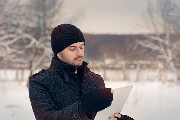 istock Man with Tablet Outside in Winter Decor 498993602