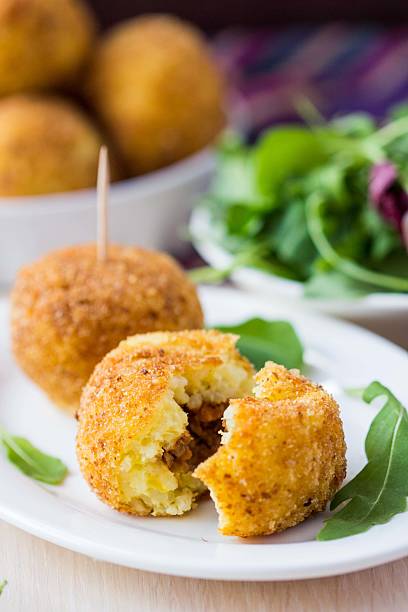 istock Italian appetizer arancini, rice balls stuffed with meat in oil 498996721