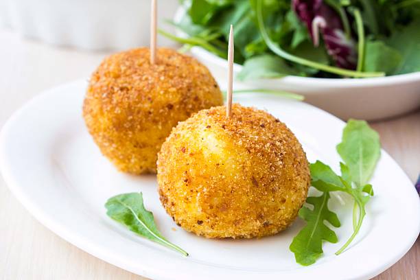 istock Italian appetizer arancini, rice balls stuffed with meat in oil 498996729