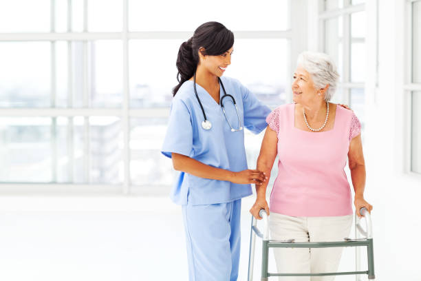 istock Nurse Helping Senior Woman With Walker While Looking At Her 498998567