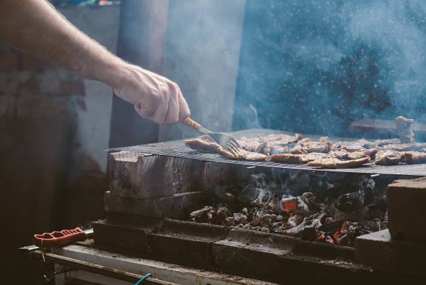 istock Man grilling pork meat chops on barbecue 498999406