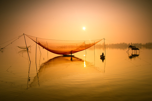 Pescador controla su NET en Río en Hoian, Vietnam photo