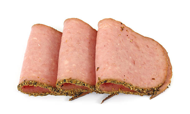 Deli fresh turkey pastrami Several slices of deli fresh turkey pastrami on a white background. pastrami stock pictures, royalty-free photos & images