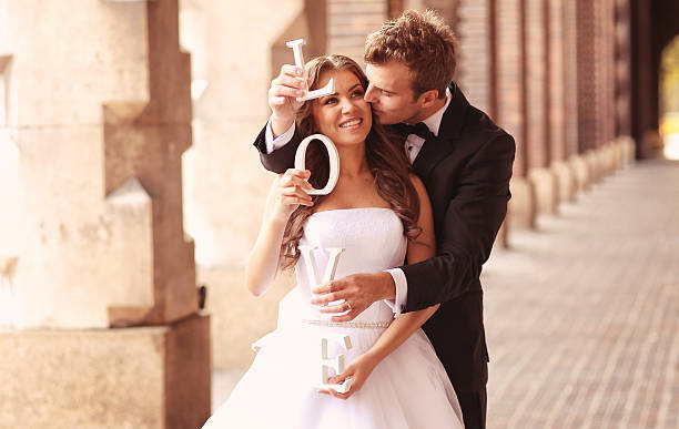 istock Happy bride and groom holding LOVE letters 499001457