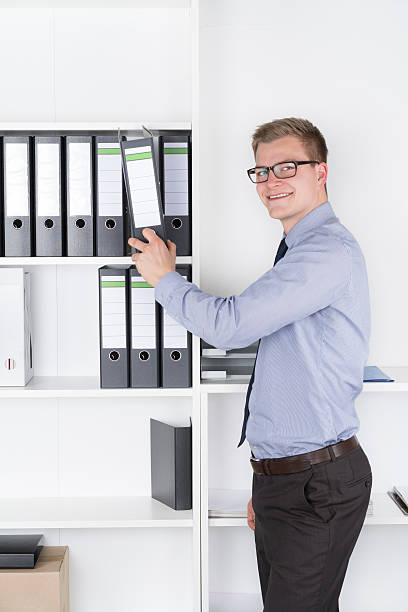 istock Man is taking out a file of the shelf 499002069