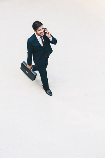 Young businessman talking on the phone and smiling.
