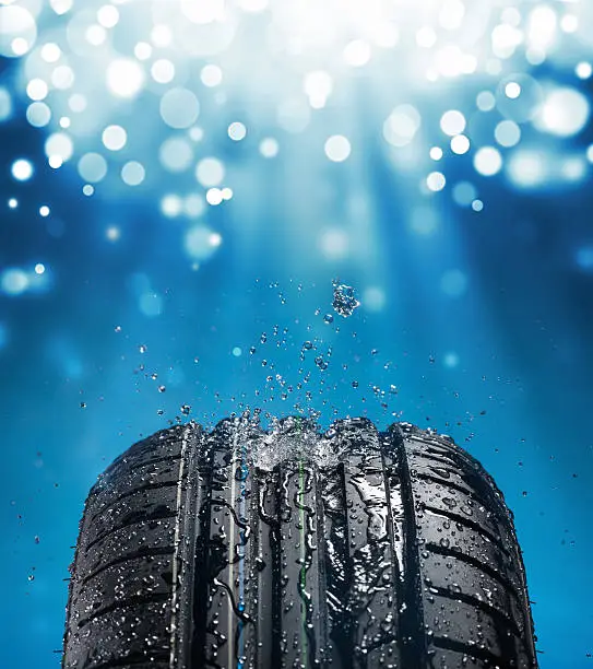 Photo of New wet tire while raining with blue light and sparkles