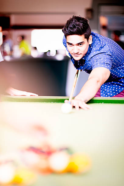 istock Mixed race man playing pool game in pub 499025974