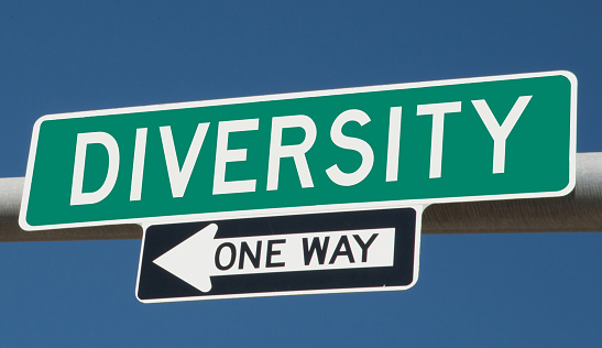 Diversity printed on green overhead highway sign with one way arrow