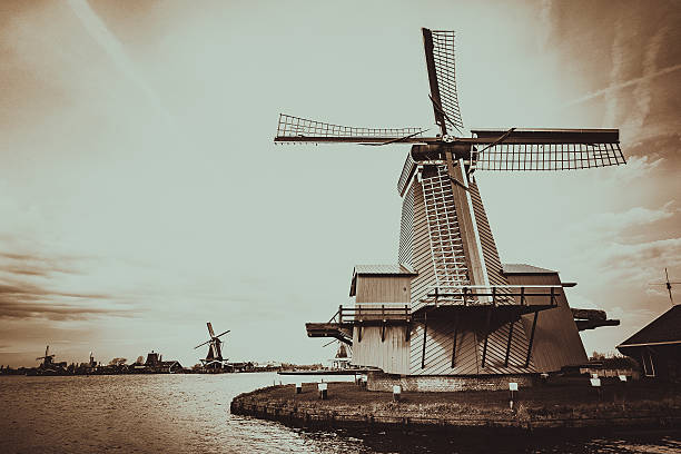 Traditional Windmills from Netherlands. This image was taken from the viewing dock at Zaanse Schans, just north of Amsterdam along the Zaans River. The village, with its traditional green wooden houses and 5 operational windmills, is the oldest industrial area in Europe, dating back to the 18th and 19th centuries.