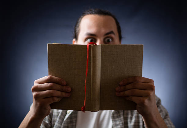 istock young man reading a book in the dark 499029408