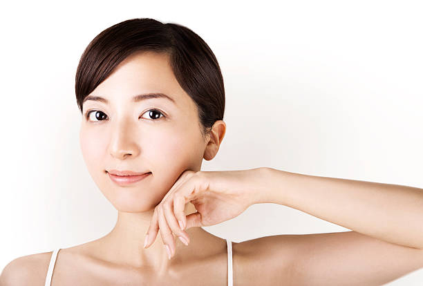 piękne azjatyckie dziewczyna dotykając jej twarz na białym tle - hair salon beauty spa indoors health spa zdjęcia i obrazy z banku zdjęć