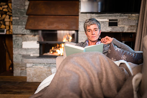 istock woman reading a book on the couch 499030884