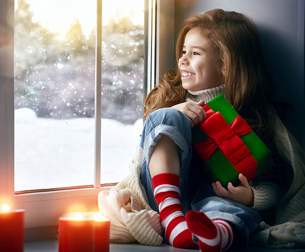 istock little girl sitting by the window 499030964