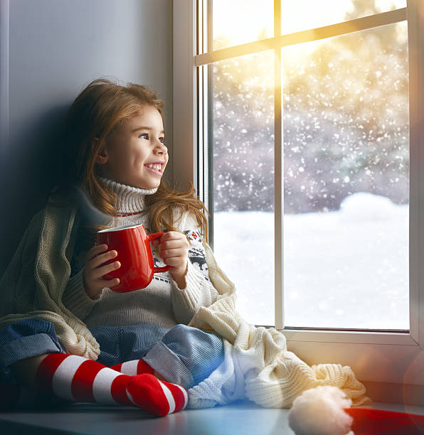 istock little girl sitting by the window 499031004